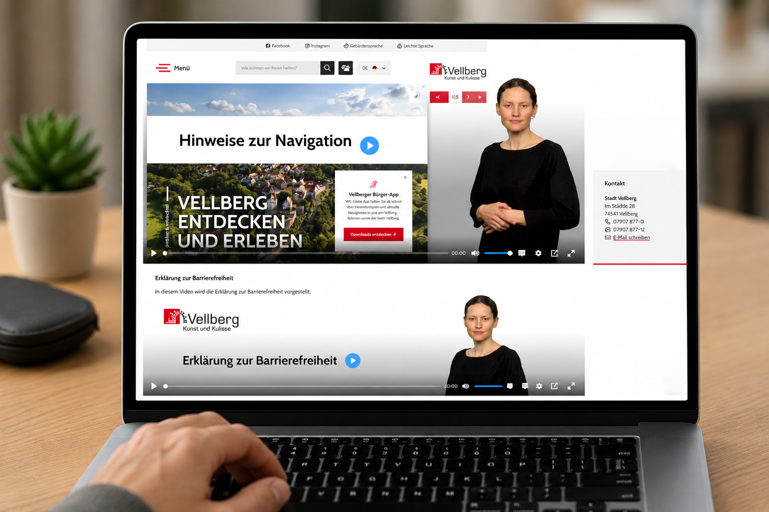 Laptop zeigt die barrierefreie Website der Stadt Vellberg mit eingebetteten Gebärdensprachvideos nach BITV 2.0. Nutzerinnen und Nutzer erhalten Informationen wie Navigation und Erklärung zur Barrierefreiheit in Deutscher Gebärdensprache direkt auf der Internetseite.